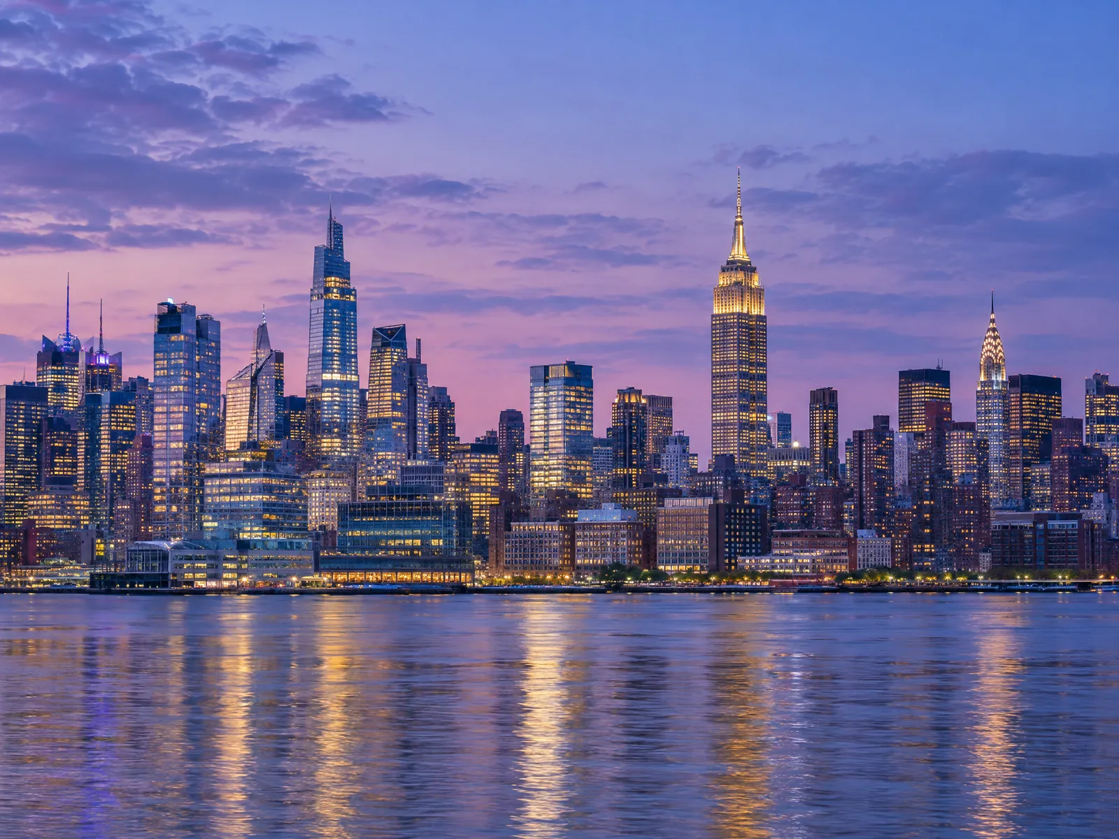 City skyline of glowing office towers at blue hour