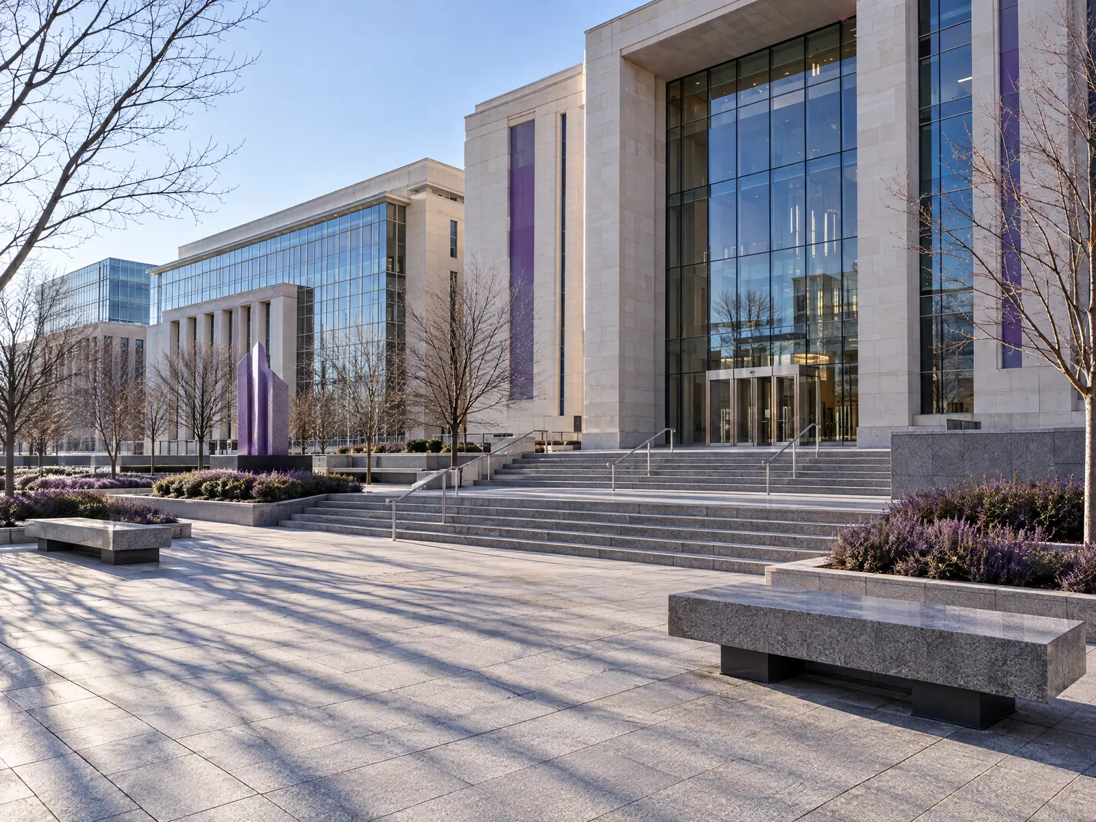 Granite plaza with benches and wide steps before limestone and glass civic buildings
